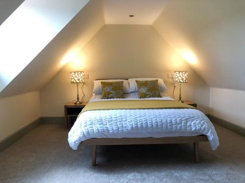 a bedroom with a bed with two lamps on either side at Nan's Cottage in Beauly