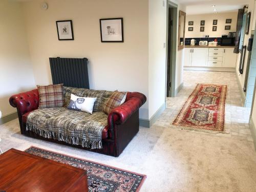 a living room with a couch and a table at Nan's Cottage in Beauly