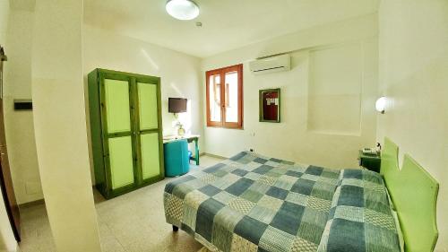 a bedroom with a bed and a green door at Hotel Meridiana in Arbus