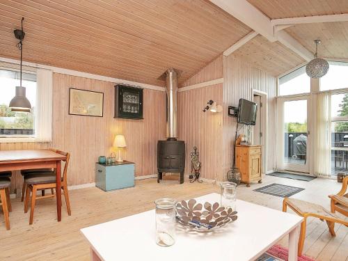 uma sala de estar com uma mesa e um fogão em 6 person holiday home in Frederikshavn em Frederikshavn