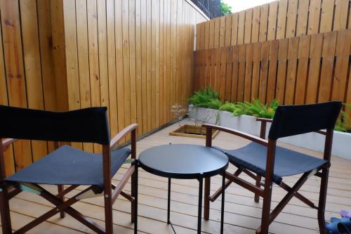 two chairs and a table on a patio with a fence at CoffeeLoft in Taitung City