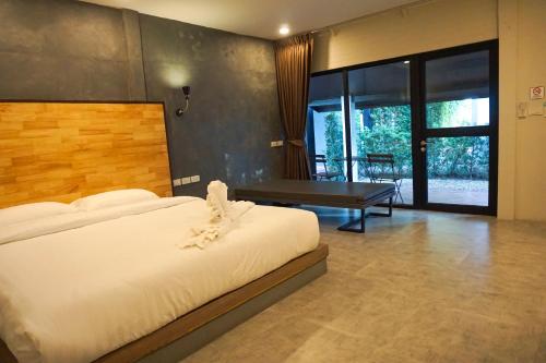 a bedroom with a bed and a bench and a table at Banyan Resort @Rayong in Ban Phe