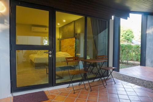 een kamer met een glazen deur met een bed en een tafel bij Banyan Resort @Rayong in Ban Phe