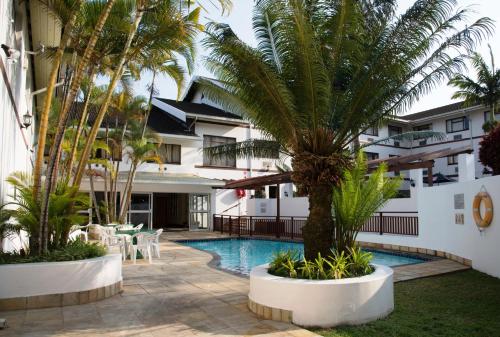 a resort with a swimming pool and palm trees at Premier Splendid Inn Pinetown in Pinetown