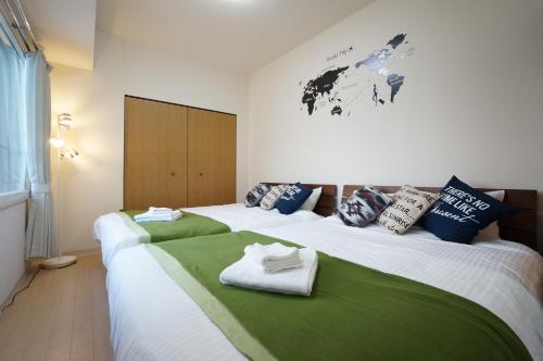 twee bedden in een kamer met groen en wit bij Downtown area Spacious cozy room Susukino IK901 in Sapporo