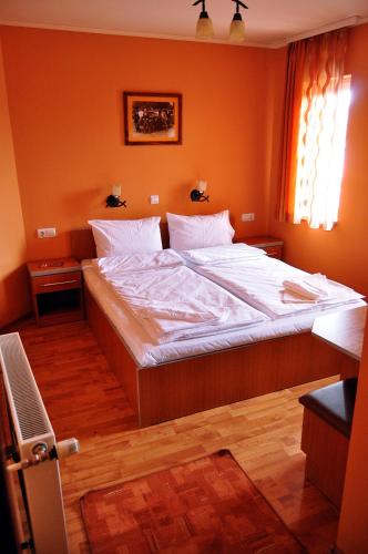 a large bed in a bedroom with orange walls at Capone in Satu Mare