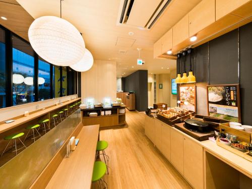 a fast food restaurant with green chairs and a counter at Super Hotel Tokyo Kinshicho Ekimae in Tokyo