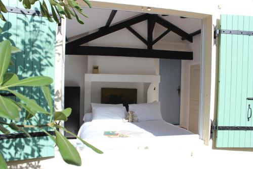 a bedroom with a white bed with a wooden canopy at Villa Kumquats in Béziers
