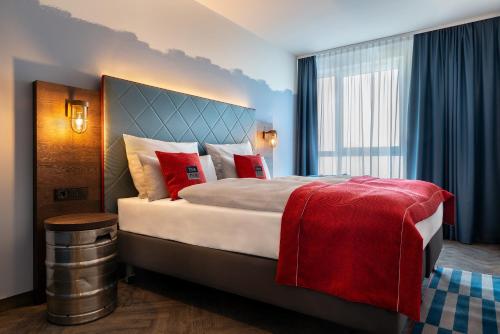 una habitación de hotel con una cama grande con almohadas rojas en the niu Keg, en Hamburgo