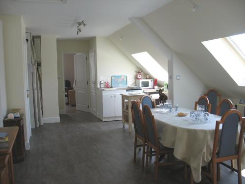 a dining room with a table and a kitchen at L'imprévu in Le Touquet-Paris-Plage