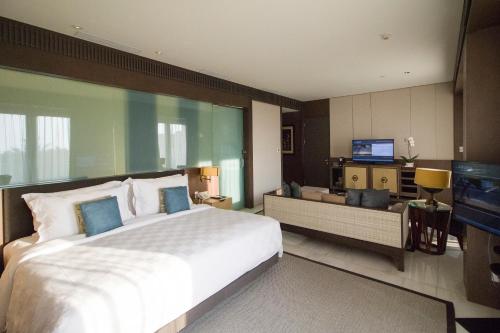 a bedroom with a large bed and a large window at The Anvaya Beach Resort Bali in Kuta