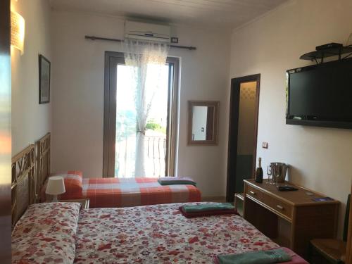 a bedroom with two beds and a flat screen tv at Casa Elvira in Isola Capo Rizzuto