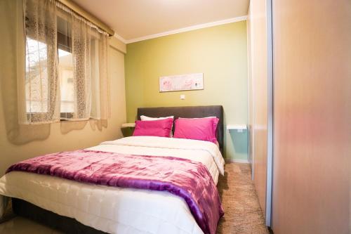 カヴァラにあるOldtown Apartmentのベッドルーム1室(ピンクの枕が付いた大型ベッド1台付)