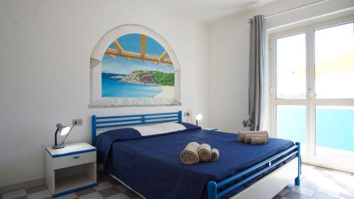 een slaapkamer met een blauw bed en een raam bij Grecale comfort House in Santa Teresa Gallura
