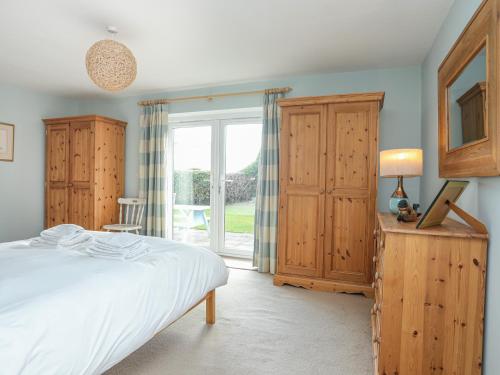 a bedroom with a bed and a large window at Curragho in Trearddur