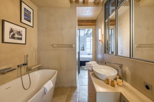 une salle de bain avec une baignoire, un lavabo et un miroir dans l'établissement Veeve - Saint-Louis Style, à Paris