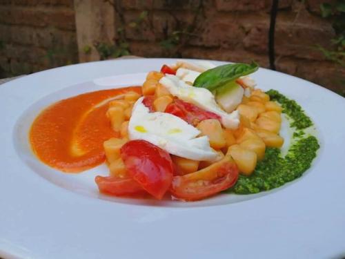 a white plate of food with tomatoes and sauce at I Cardinali in Santa Marinella