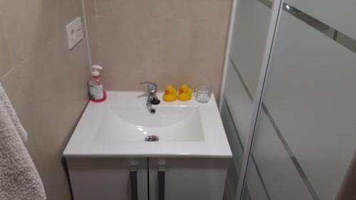 W łazience znajduje się biała umywalka i prysznic. w obiekcie Acogedora Habitación Centro Bilbao w mieście Bilbao