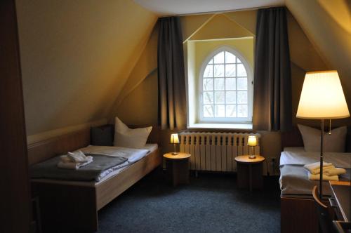 a small room with two beds and a window at Zentrum Kloster Lehnin in Lehnin