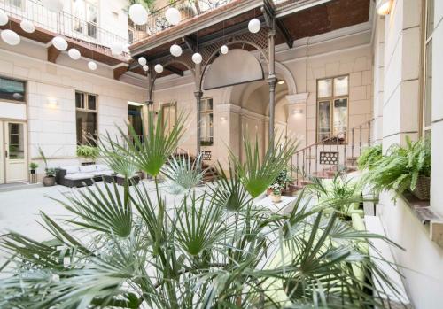 a large building with plants in the courtyard at Harmonia Palace - Luxury Apartments in Budapest