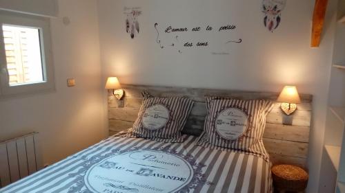 a bedroom with a bed with two pillows with writing on the wall at CHALET DU LAC PISCINE à 5 MINUTES DE DISNEY TGV RER in Montévrain