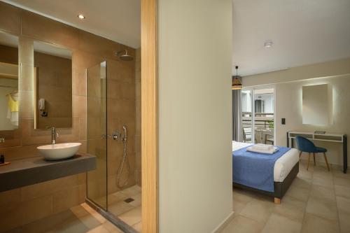 a bathroom with a bed and a sink and a shower at Mare Boutique in Georgioupolis
