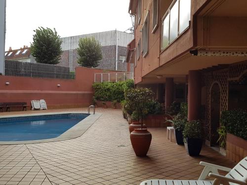a courtyard with a pool and potted plants next to a building at Dúplex Nigrán in Nigrán