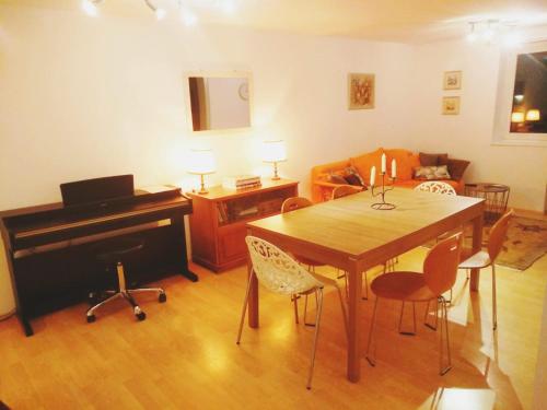 ein Wohnzimmer mit einem Tisch und einem Klavier in der Unterkunft Dimai House No 16 Dornbirn Zentrum in Dornbirn