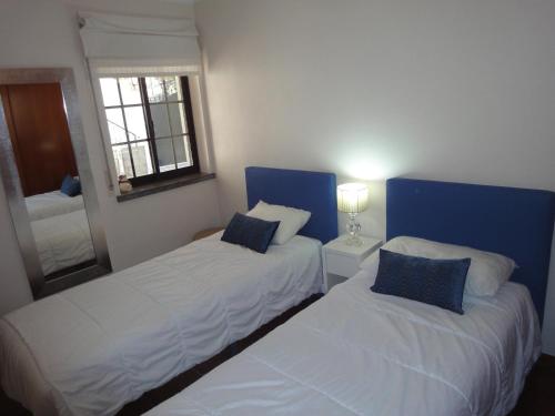a bedroom with two beds and a mirror at Orchidea Terrace in Malveira da Serra