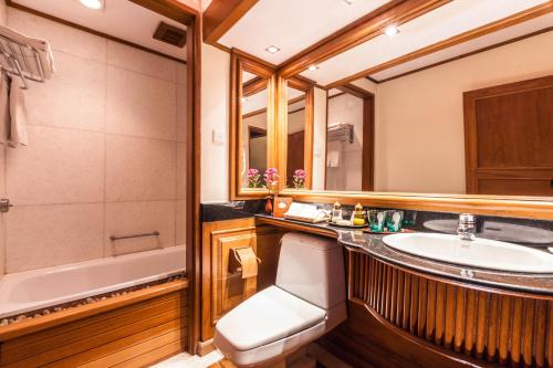 a bathroom with a sink and a tub and a toilet at The Hotel by the Red Canal in Mandalay