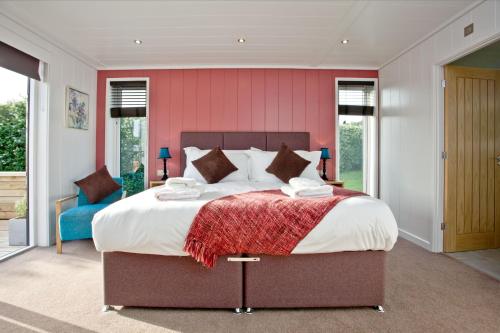 um quarto com uma cama grande e uma parede vermelha em Combe Hay, Strawberryfield Park, Cheddar em Cheddar