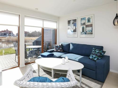 a living room with a blue couch and a table at 4 person holiday home in Bogense in Bogense