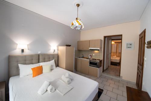 a bedroom with a large white bed and a kitchen at Mavra Studios in Lygia