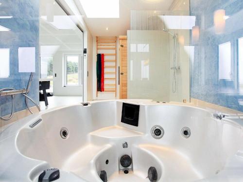 a large white tub in a bathroom with a tv at 8 person holiday home in Kalundborg in Kalundborg