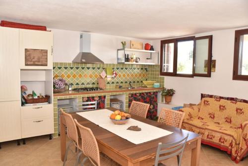 a kitchen with a table with a bowl of fruit on it at Affittacamere Casa Maica in Stintino