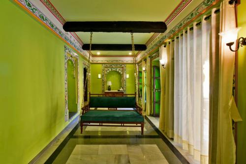 a bedroom with green walls and a green bed at Gogunda Palace in Udaipur