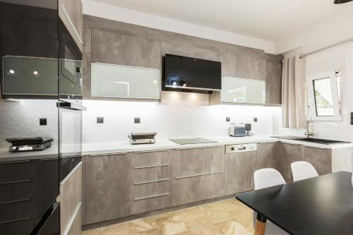 a kitchen with white and gray cabinets and a table at Ocean Dream Apartment! in Balíon