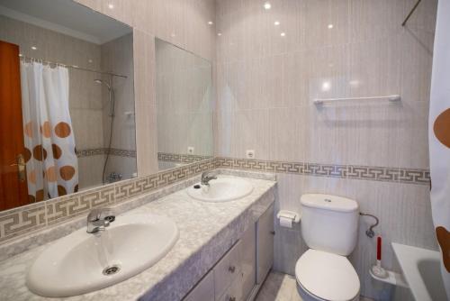uma casa de banho com 2 lavatórios, um WC e um espelho. em HACIENDA 19 MENYBER em Nerja
