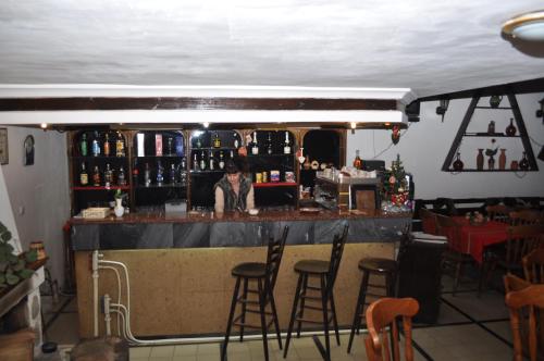 a man standing at a bar in a restaurant at Hotel Alpin - 91 Bansko in Bansko