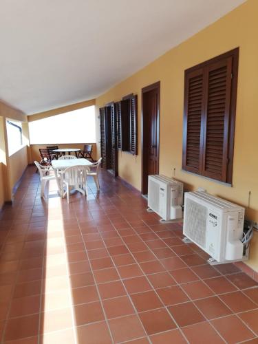 a room with a tiled floor with tables and chairs at Il Castagno in Marciana