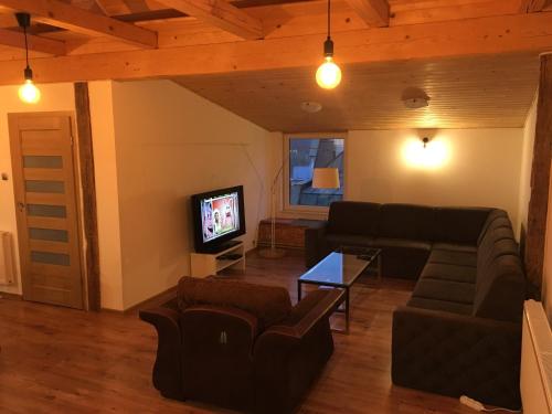 a living room with a couch and a tv at Apartamenty na Starówce - Apartments in the Old Town in Cieszyn