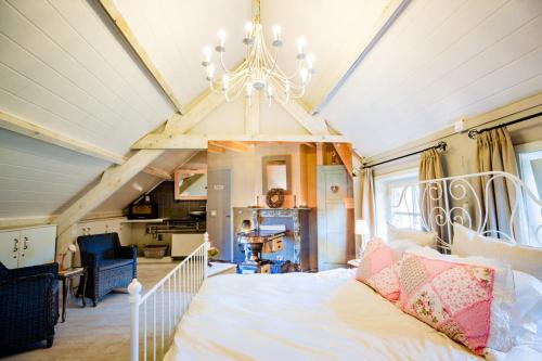 a bedroom with a white bed and a chandelier at Bij de Zöster in Kinrooi