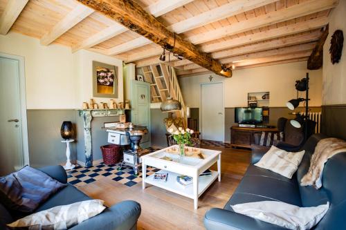 ein Wohnzimmer mit einem Sofa und einem Tisch in der Unterkunft Bij de Zöster in Kinrooi