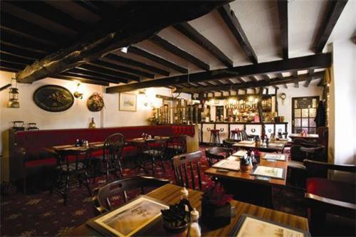 a restaurant with tables and chairs and a bar at Red Lion Dunston in Branston