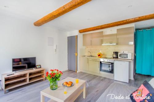 een woonkamer met een tafel en een keuken bij Enjoyable studio just by the sea - Dodo et Tartine in Toulon