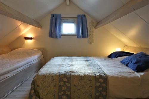 a bedroom with two beds and a window at Vakantiehuis Merel in Den Helder