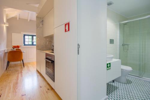 a bathroom with a toilet and a glass shower at Barão Oporto Apartments in Porto