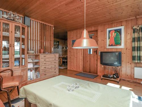 a dining room with a table and a tv at 4 person holiday home in Bog By in Bogø By