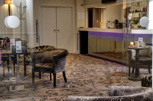 a living room with a table and chairs and a kitchen at Ivy Hill Hotel, Sure Hotel Collection by Best Western in Chelmsford