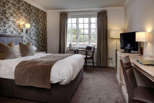 a hotel room with a large bed and a desk at Ivy Hill Hotel, Sure Hotel Collection by Best Western in Chelmsford